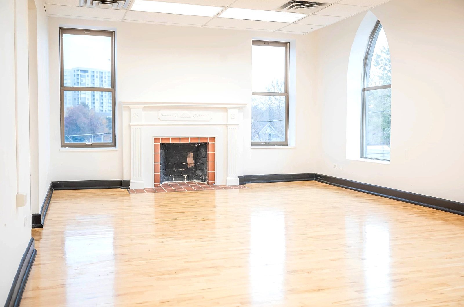 Upper level office with fireplace and arched window at 910 Galapago St