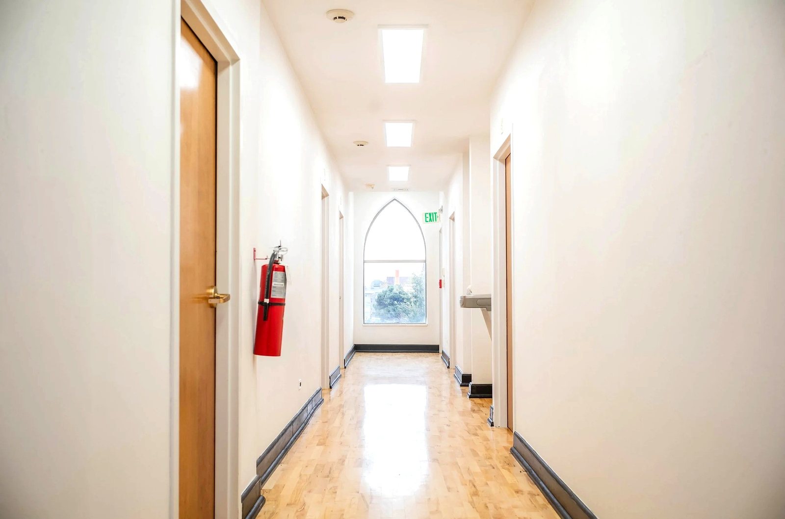 Upper level hallway toward the arched chapel window